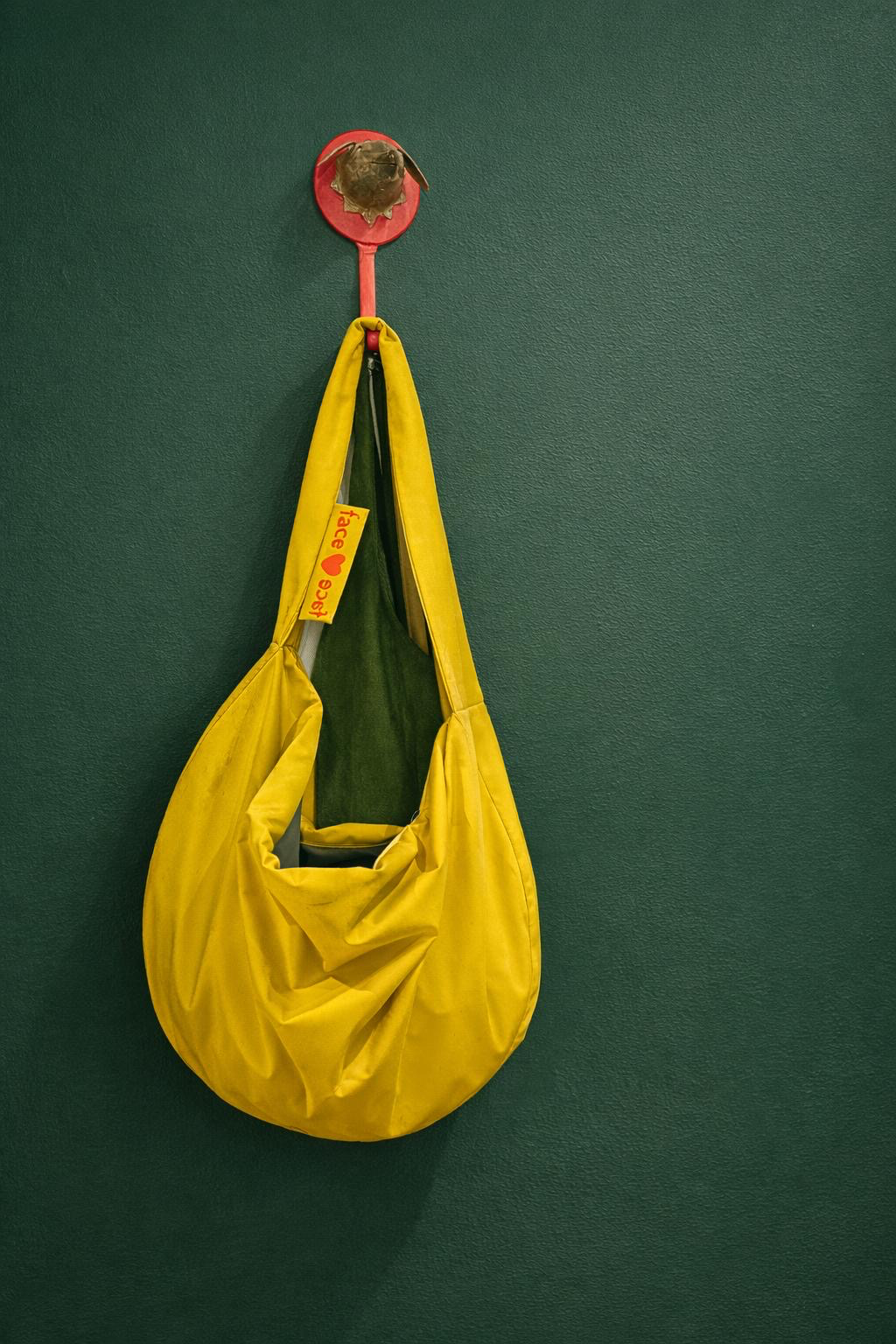 Gelbe Facetoface Tasche an grüner Wand